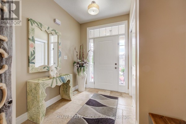 Interior entryway with tiled floor, console table, mirror, and white door with glass panels. - 300 Watervale Crescent, Kitchener