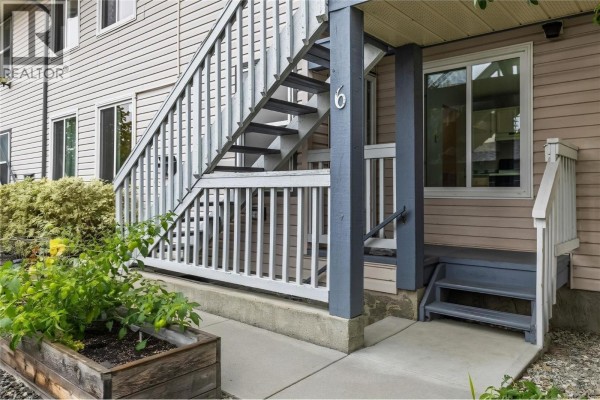 Close-up of the entrance to unit 6, showing stairs, railing, and part of the building exterior. - 3000 Richter Street Unit# 6, Kelowna