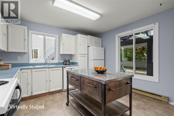 Kitchen with white cabinets, light blue countertops, sink, dishwasher, stove, and refrigerator. - 3000 Richter Street Unit# 6, Kelowna