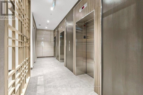 Modern hallway with three stainless steel elevators and a textured wood accent wall. - 3001 - 47 Mutual Street, Toronto