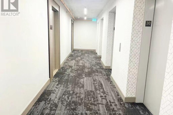 Hallway with patterned carpet and elevators on both sides, leading down a corridor. - 3001 - 47 Mutual Street, Toronto