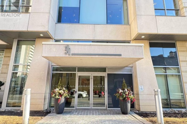 Entrance to the building with glass doors, stone facade, and planters. - 3001 - 500 Sherbourne Street, Toronto
