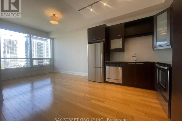 Open concept living area with hardwood floors and a view of city buildings. - 3001 - 500 Sherbourne Street, Toronto