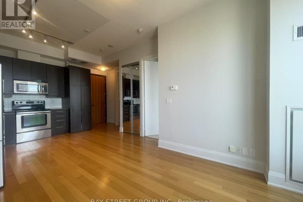View of the open living space, kitchen, and mirrored closet doors. - 3001 - 500 Sherbourne Street, Toronto