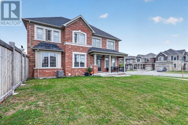 Side view of a brick house with a grass lawn and adjacent homes. - 3001 Hollyberry Trail, Pickering