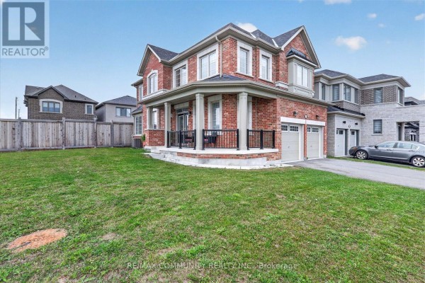 Corner view of the brick house showing the porch, lawn, and attached garage. - 3001 Hollyberry Trail, Pickering