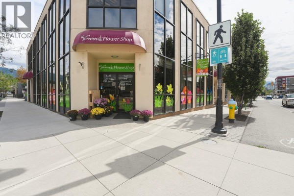 Side view of a beige commercial building with a dark-windowed facade and a parking lot in front. - 3003 30 Street, Vernon