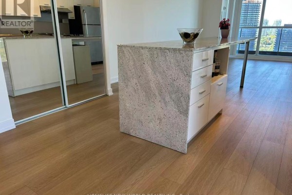Close-up of the granite-topped kitchen island with white cabinetry. - 3005 - 33 Singer Court, Toronto