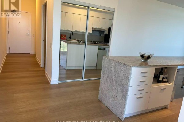 Hallway leading to the living area with mirrored closet doors and kitchen island. - 3005 - 33 Singer Court, Toronto