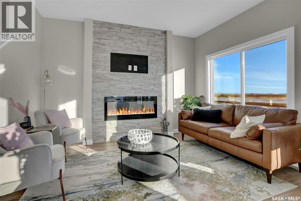 Modern kitchen with gray cabinetry, white quartz countertops, a large island, and stainless steel appliances. - 3005 Green Turtle Road, Regina