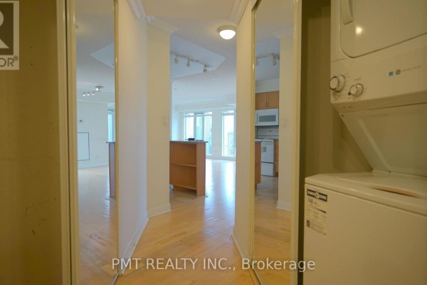 View through mirrored closet doors into living room, kitchen, and dining area. - 3008 - 210 Victoria Street, Toronto