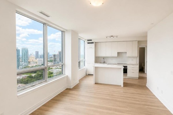 Kitchen area with white cabinets, an island, and large windows overlooking a cityscape. - 3008 - 36 Elm Drive W, Mississauga