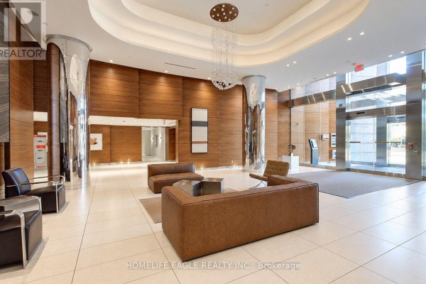 Luxurious apartment building lobby with leather sofas, wood paneling, and a crystal chandelier. - 3008 - 5 Valhalla Inn Road, Toronto