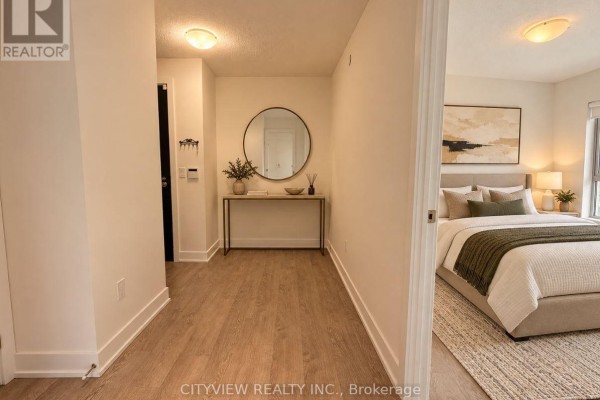 Apartment hallway with a round mirror and a doorway to a bedroom. - 3009 - 7 Mabelle Avenue, Mississauga
