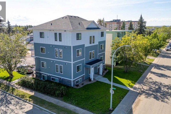 Three-story apartment building from an elevated angle showing surrounding street and neighboring buildings. - 301, 10101 105 Avenue, Grande Prairie