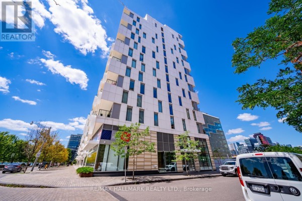 Exterior view of the apartment building with geometric white panels and windows. - 301 - 118 Merchants' Wharf, Toronto