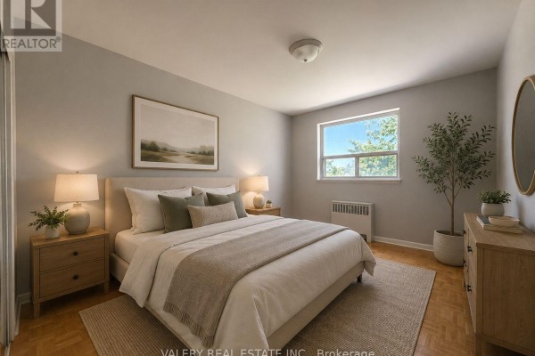 Bedroom with a queen-sized bed, neutral bedding, wooden nightstands, a dresser, and a window overlooking trees. - 301 - 1725 Lawrence Avenue E, Toronto
