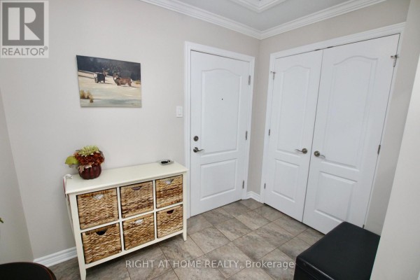 Close-up of apartment entryway with artwork, storage, and doors. - 301 - 2 Warner Street, Russell