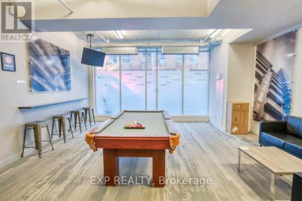 Rec room with a pool table, stools, artwork, and a large frosted window. - 301 - 383 Cumberland Street, Ottawa