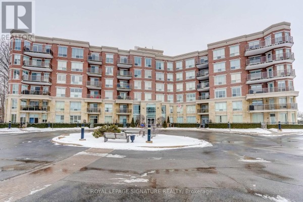 Brick condo building with balconies and large windows, entrance, bench, snowy landscaping - 301 - 483 Faith Drive Mississauga