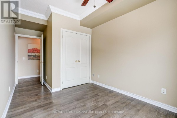Bedroom with hardwood floors, closet, and crown molding - 301 - 483 Faith Drive Mississauga