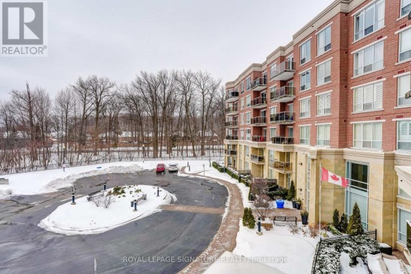 Brick apartment building with balconies and snow-covered parking lot - 483 Faith Drive Mississauga