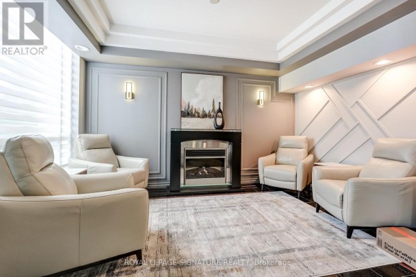 Living room with fireplace, recliner chairs, and tray ceiling - 301 - 483 Faith Drive Mississauga