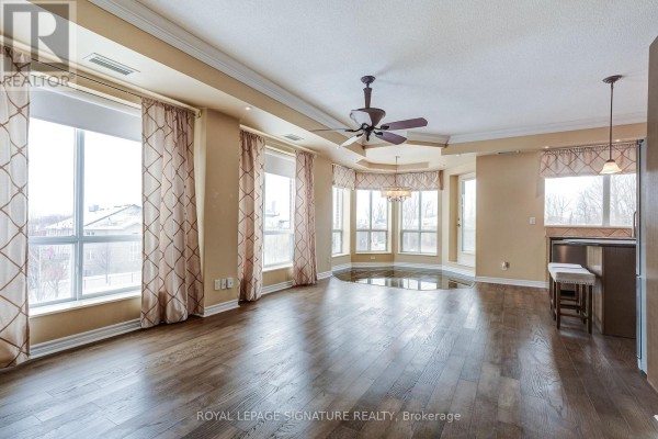 Living room with hardwood floors, bay window, chandelier & ceiling fan - 301 - 483 Faith Drive Mississauga