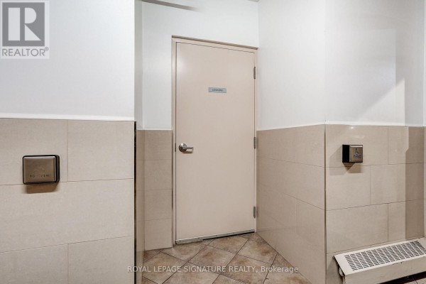 Hallway with lockers door, accessible opener, and tiled walls - 301 - 483 Faith Drive Mississauga