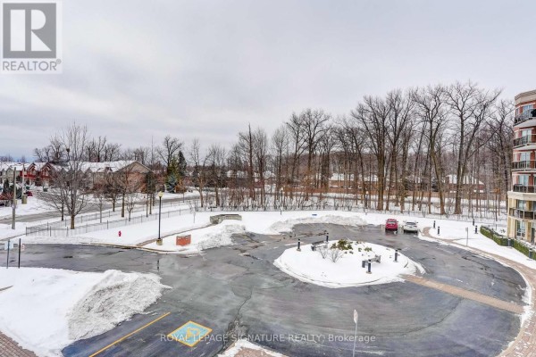 Snowy parking lot with benches and trees, apartment building - 301 - 483 Faith Drive Mississauga