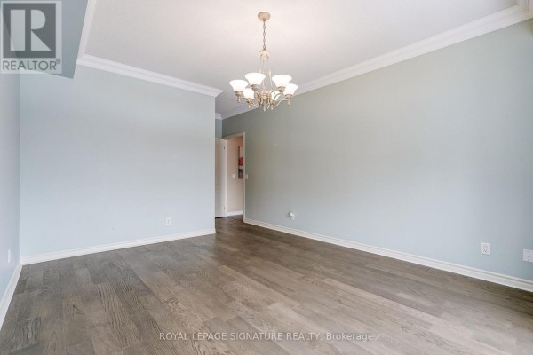 Light blue living room with hardwood floors, crown molding, and chandelier - 301 - 483 Faith Drive Mississauga