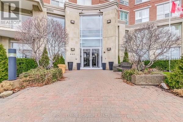 Building entrance with glass doors, stone facade, bench, and planters - 483 Faith Drive Mississauga