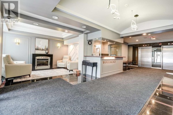 Lobby with reception desk, fireplace, sitting area, and elevators - 301 - 483 Faith Drive Mississauga