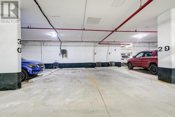 Parking garage with spots 30 and 29, vehicles, and shopping carts - 301 - 483 Faith Drive Mississauga