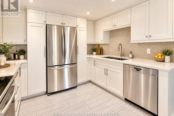 View of the kitchen sink, dishwasher, stainless steel refrigerator, white cabinets, and tiled backsplash. - 301 - 55 Carscadden Drive, Toronto