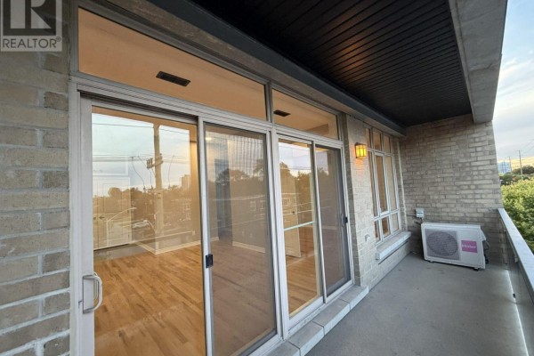 Balcony view from apartment with sliding glass doors, light wood floors, and outdoor AC unit. - 301 - 682 Churchill Avenue N, Ottawa