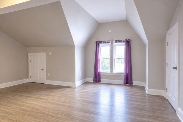 Unfinished room with sloped ceiling, light grey walls, white trim, and light wood flooring. - 301 - 72 Victoria Avenue S, Hamilton