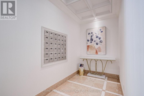 A hallway area with a wall of mailboxes, a decorative console table, and modern artwork. - 301 - 96 Fifeshire Road, Toronto