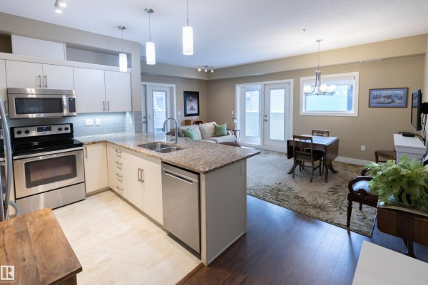 Open concept living and kitchen area with granite countertops, stainless steel appliances, and dining table. - #301 111 Festival Wy, Sherwood Park