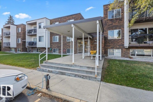 Exterior of the apartment building with a covered entrance and concrete steps. - #301 11465 41 Av Nw, Edmonton