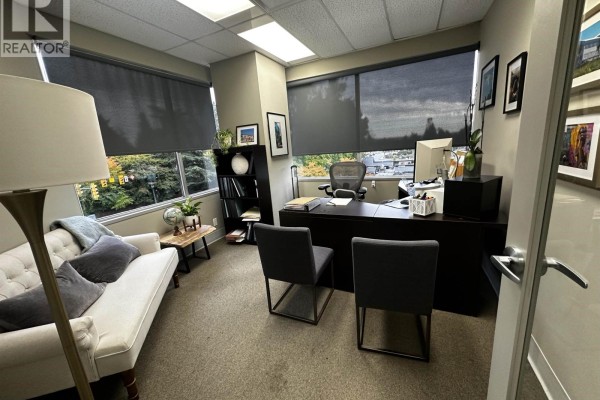Office space with a desk, chairs, a sofa, and windows with blinds. - 301 2609 Westview Drive, North Vancouver