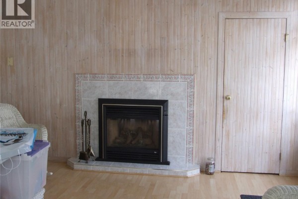 Side view of the residence showcasing brick and stone exterior with large windows. - 301 5th Street W, Leader