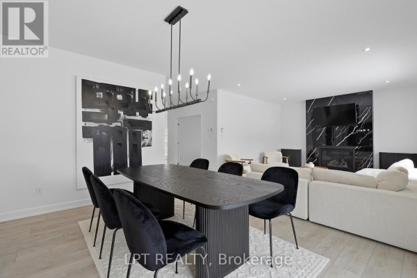 Modern living and dining room with marble fireplace, abstract art, and dining set - 301 Moonlight Drive Russell