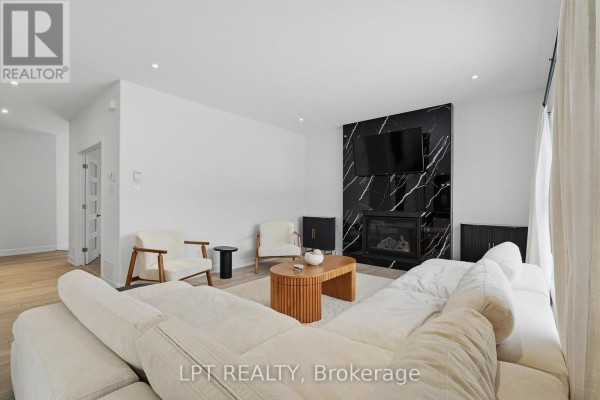Modern living room with marble fireplace, TV, sectional sofa, and wood coffee table - 301 Moonlight Drive Russell