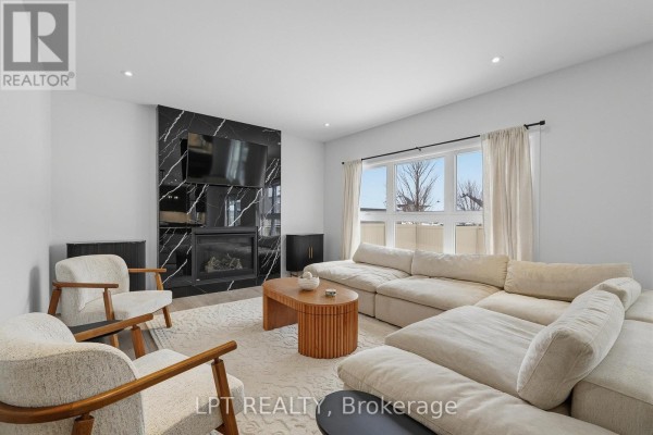 Living room with marble fireplace, sectional sofa, armchairs, and large windows - 301 Moonlight Drive Russell