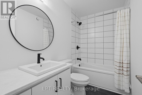 Modern bathroom with round mirror, subway tile shower, and white vanity - 301 Moonlight Drive Russell