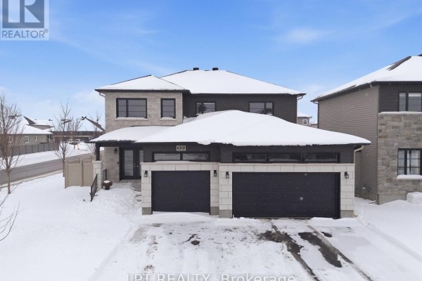 Modern home with stone accents, two-car garage, and house number 301 - 301 Moonlight Drive Russell