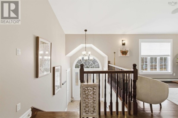 View from above looking down at a staircase railing, arched entryway, and part of a living room. - 301 Preakness Crescent, Fall River
