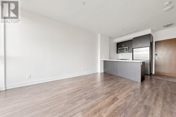 Living and kitchen area with wood flooring and grey kitchen cabinets. - Unit #415 - 301 Sea Ray Avenue, Innisfil