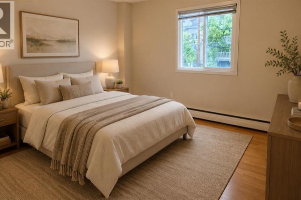 Small bedroom with hardwood flooring and a window allowing natural light. - 302, 117 23 Avenue Sw, Calgary